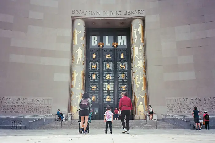 a family stands outside the Brooklyn Public Library